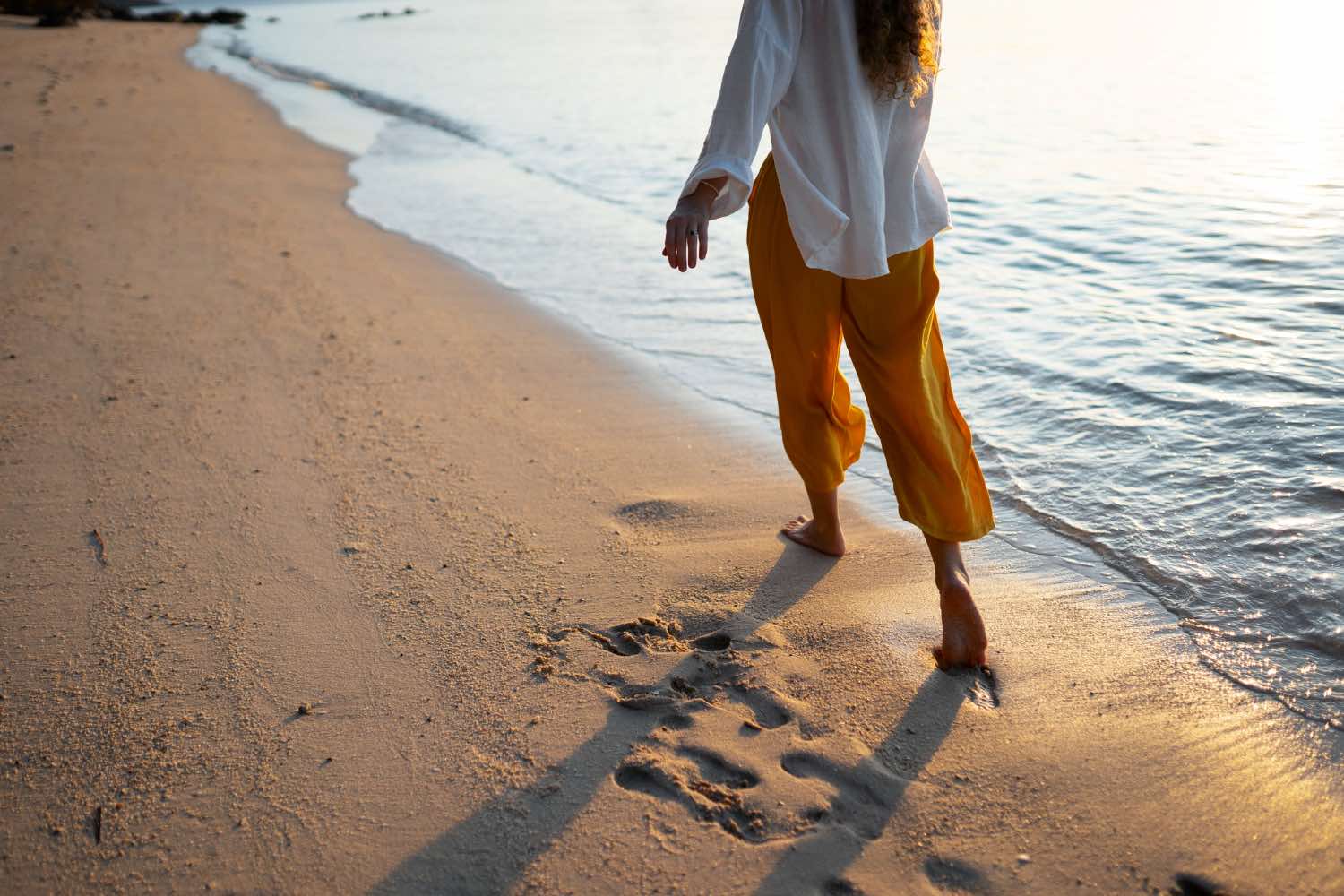 Woman reducing anxiety walking along a sunny Sunshine Coast beach as a simple daily strategy