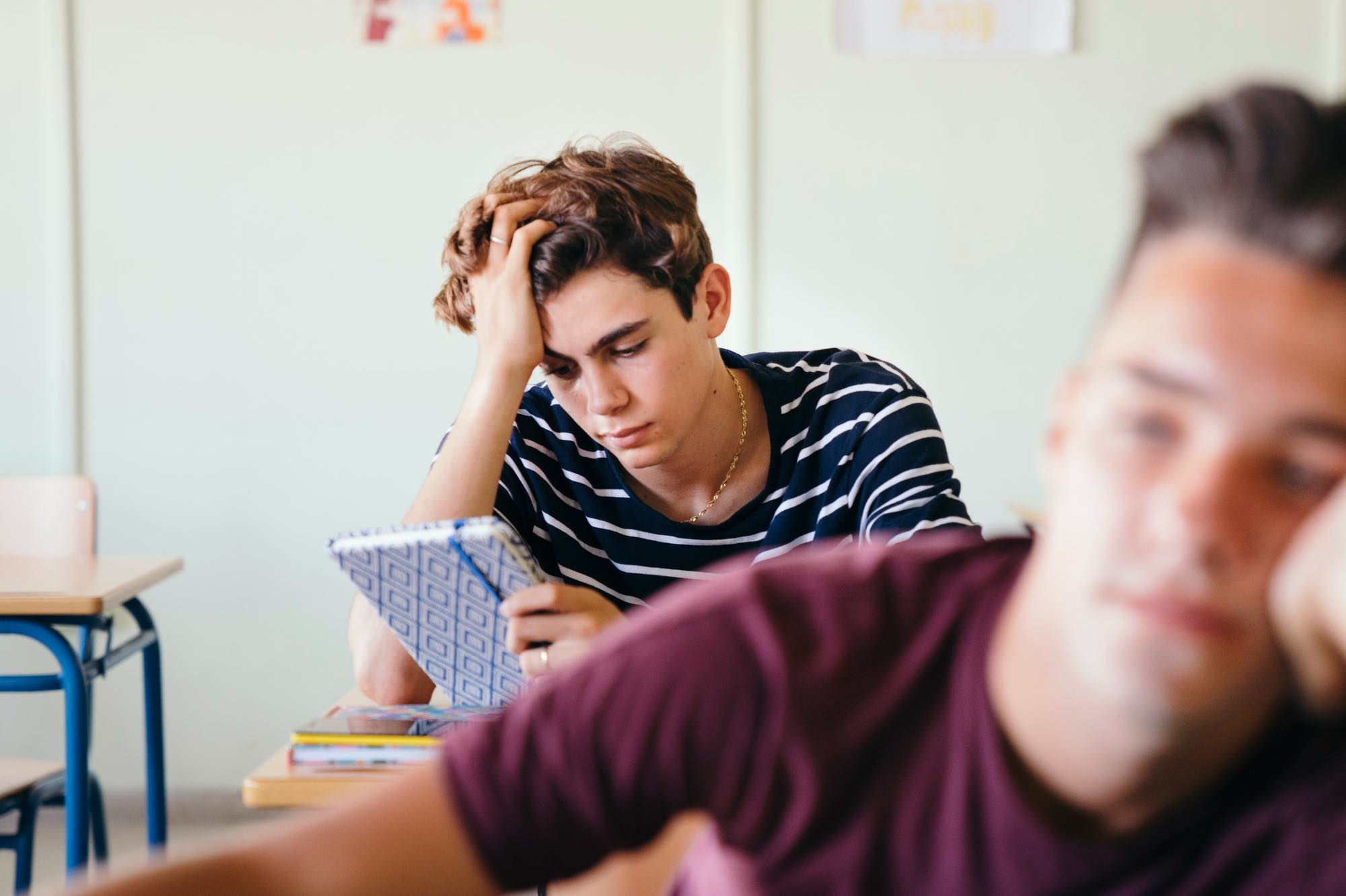 Mid-term stress and anxiety in children on the Sunshine Coast depicted by tired teens sitting at school desks