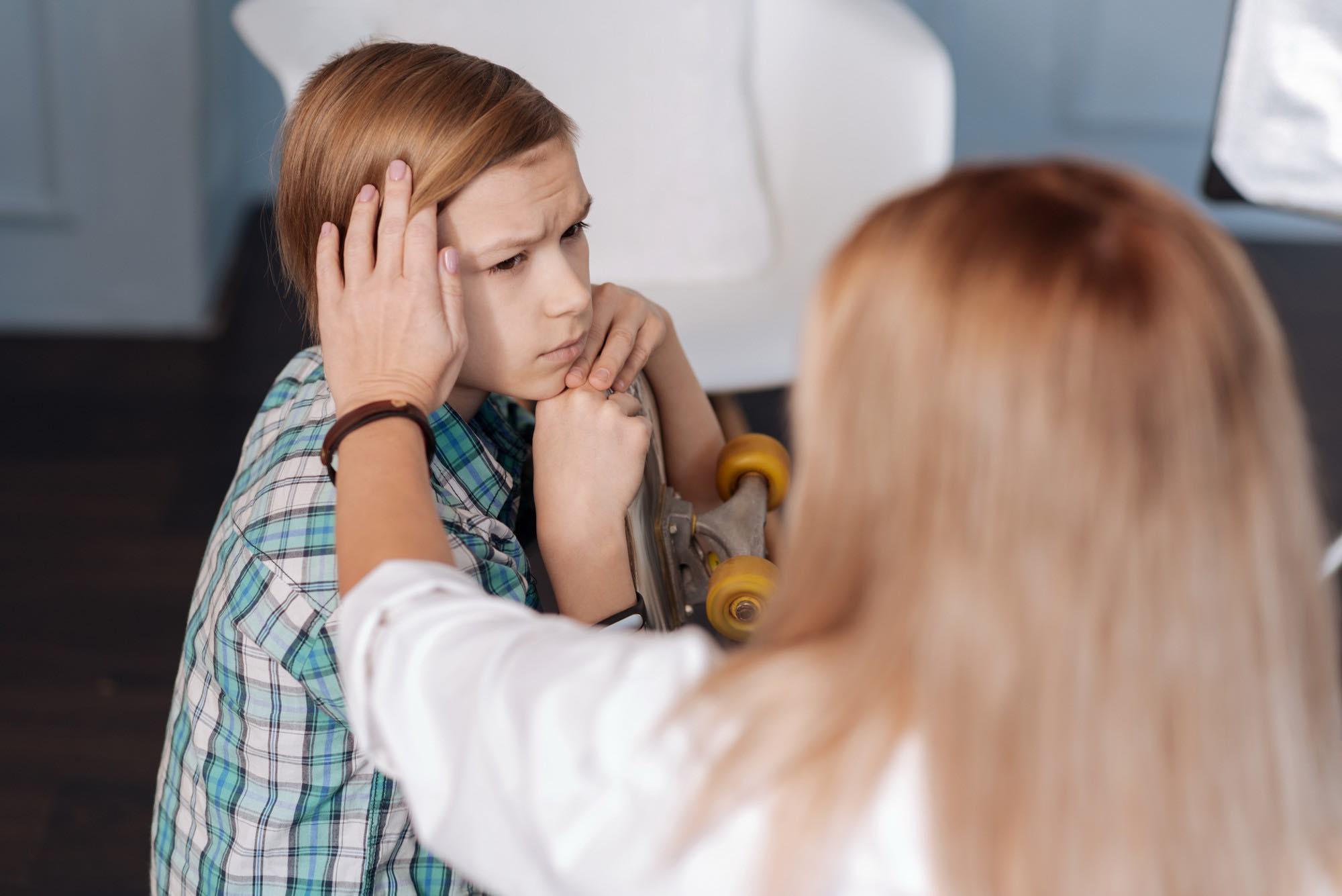 Teen anxiety signs, worried young boy with hand on head being comforted by a parent, illustrating how parents can recognise and support anxiety in teenagers on the Sunshine Coast